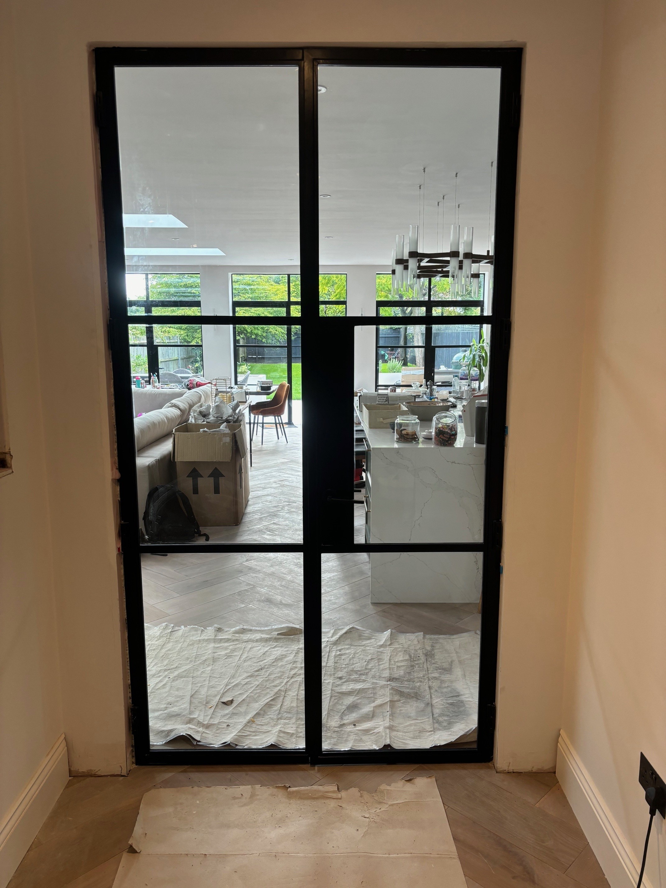 Internal black steel-framed glazed doors leading through to a kitchen