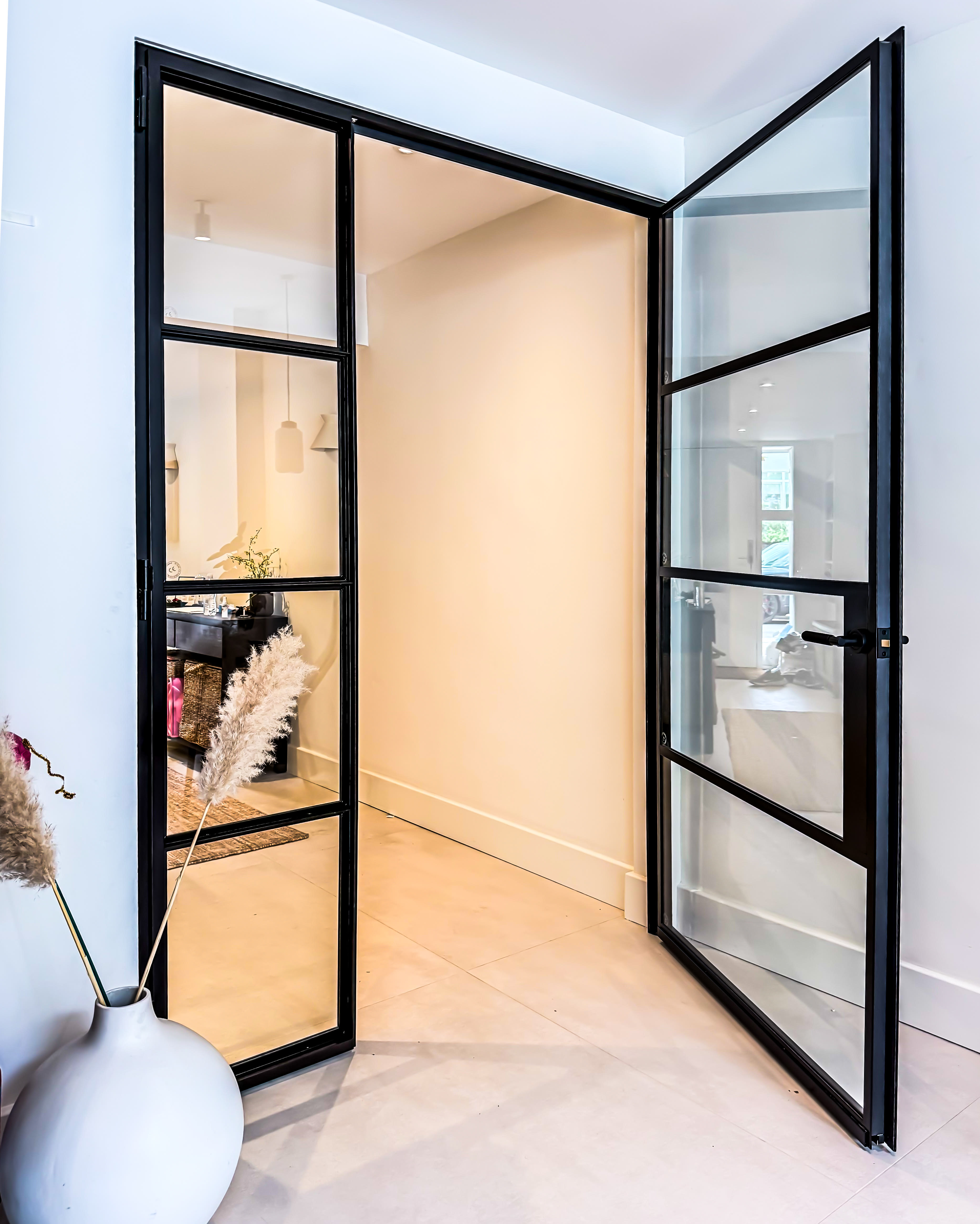 Internal black steel-framed glazed doors leading through to a kitchen